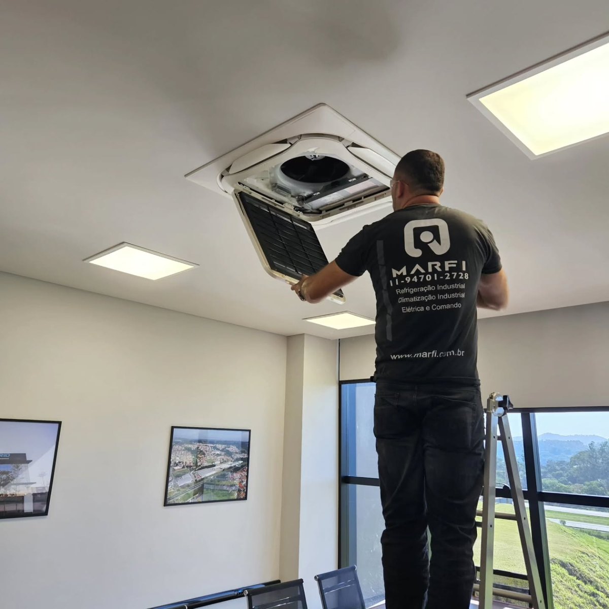Técnico da MARFI realizando manutenção preventiva em ar-condicionado cassete